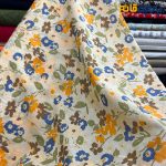 پارچه بهاره و تابستانه وال طرحدار کره زمینه لیمویی روشن خاص گل نارنجی سرمه ای.