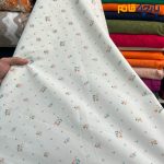 پارچه بهاره و تابستانه کتان نخ طرحدار زمینه شیری رنگ گل ریز نارنجی