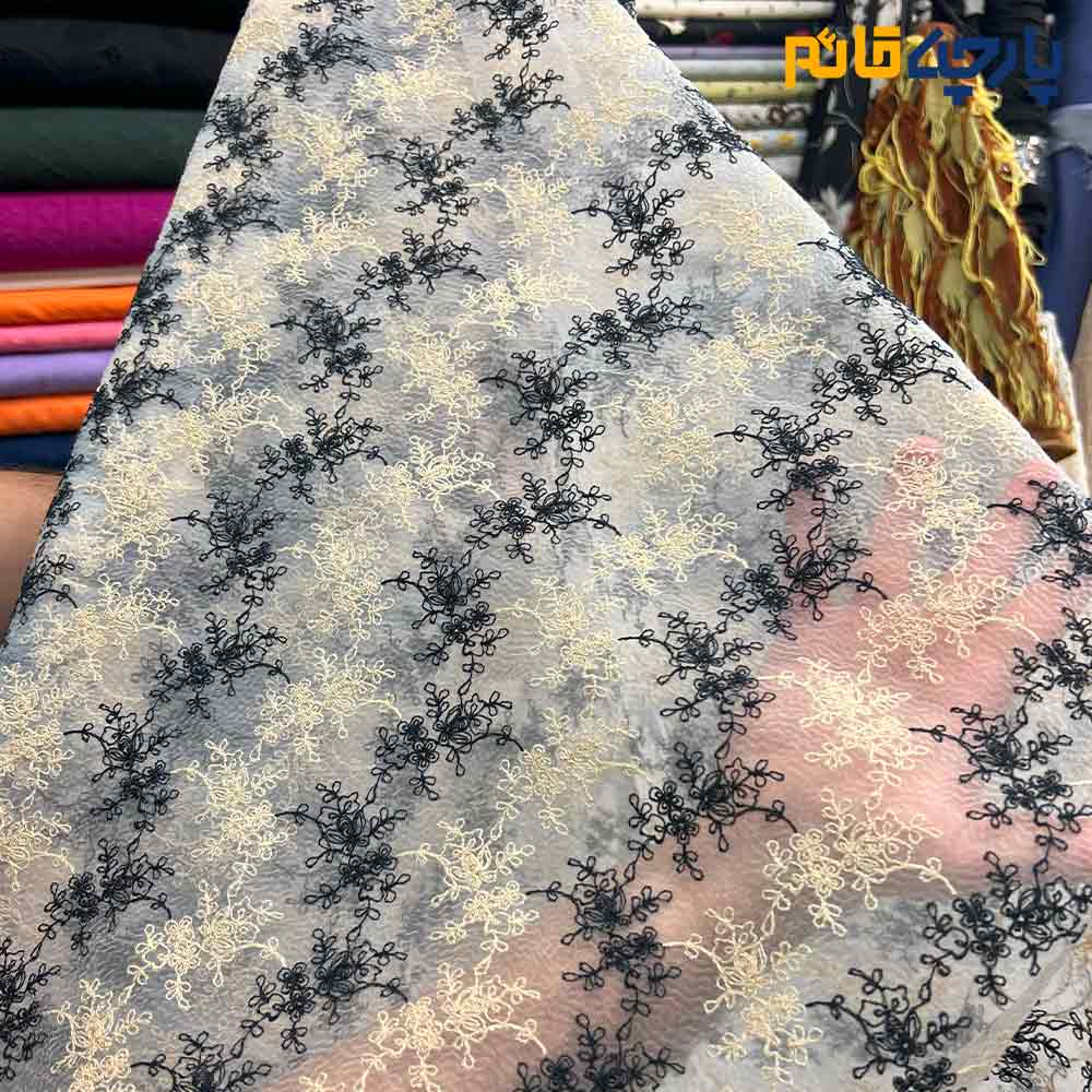 پارچه مجلسی تور کتان زمینه اورگانزا طرح گل و شاخه کرم و مشکی