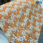 پارچه مجلسی تور کتان زمینه تور ظریف طرح برجسته رنگ نارنجی کرم عرض ۱۴۵
