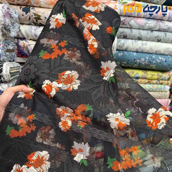 پارچه مجلسی دانتل ایتالیایی طرح گل نارنجی با زمینه مشکی و رباندوزی مشکی برجسته