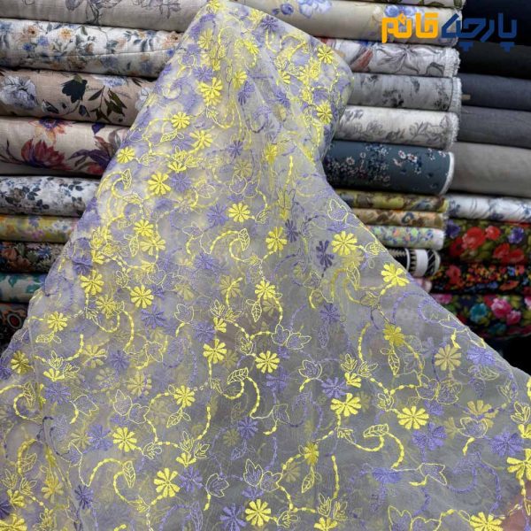 پارچه مجلسی تور کتان طرح گل متوسط زمینه اورگاندی رنگ زرد و بنفش