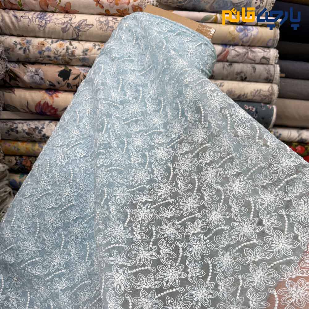 پارچه مجلسی تور کتان طرح گل و شاخه برجسته زمینه اورگانزا رنگ آبی فیروزه ای روشن