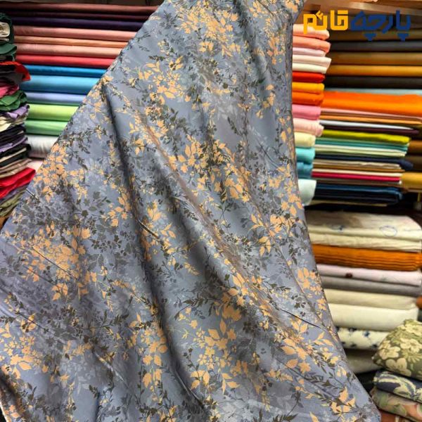 پارچه بهاره تابستانه سیلک نخ طرحدار زمینه رنگ آبی نفتی طرح شاخه و برگ ریز