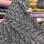 پارچه مجلسی تور کتان کره ای زمینه تور مشکی طرح گل سفید