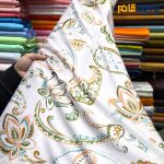 پارچه مجلسی سیلک طرحدار طرح بته جقه سبز و نارنجی زمینه روشن