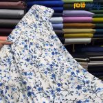 پارچه مجلسی سیلک ابریشم طرحدار زمینه سفید گل آبی کاربنی
